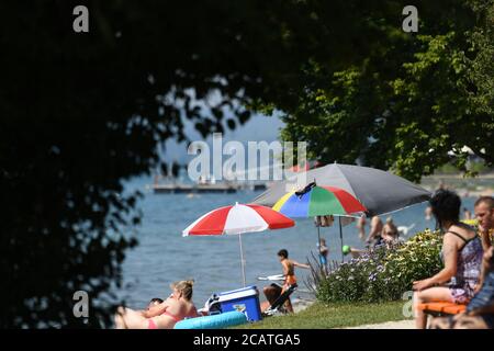Sipplingen Am Bodensee, Deutschland. August 2020. Sonnenanbeter liegen auf ihren Badetüchern an der Uferpromenade am Bodensee. Die Behörden appellieren an Touristen, sich an die Regeln der Entfernung zu halten. Quelle: Felix Kästle/dpa/Alamy Live News Stockfoto