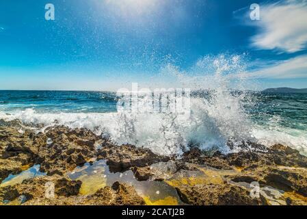 Wellen, die an einem felsigen Ufer in Sardinien, Italien, brechen Stockfoto