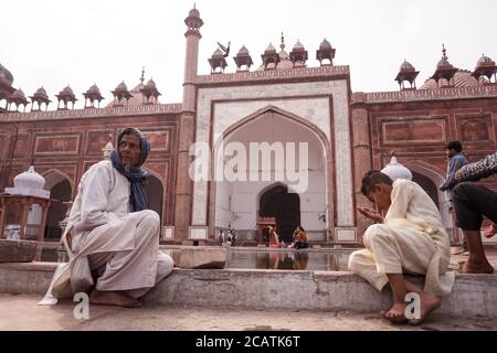 Agra / Indien - 12. Februar 2020: Gläubige sprechen am Pool im großen Innenhof der Jama-Moschee Stockfoto