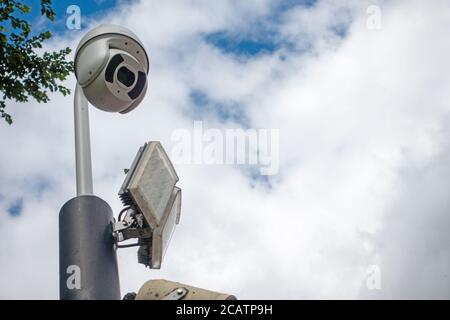 CCTV-Dome-Überwachungskamera und LED-Flutlicht auf einer Stange Am Himmel Stockfoto