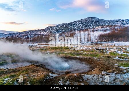 Sonnenaufgang Blick auf den großen Geysir in Island, im Winter. Stockfoto