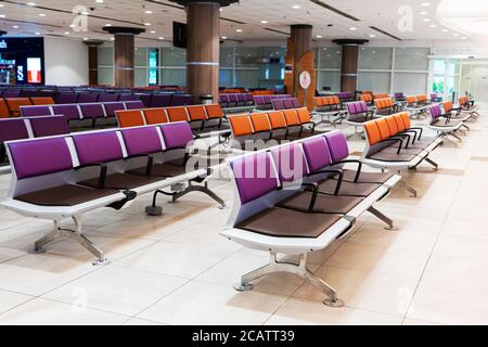 Leeres internationales Flughafengebäude während einer Pandemie. Leere Sitzreihen in der Flughafenlounge Stockfoto