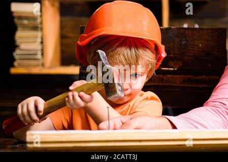 Lustige kleine Werkstatt mit Hammer. Bauarbeiter für Kinder. Kind mit einem Hammer zu nageln. Stockfoto