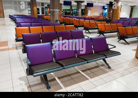 Leeres internationales Flughafengebäude während einer Pandemie. Leere Sitzreihen in der Flughafenlounge Stockfoto