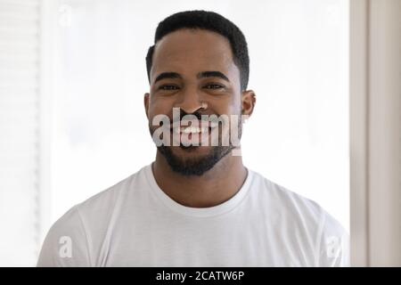 Kopf erschossen Porträt lächelnd afroamerikanischen jungen Mann trägt T-Shirt Stockfoto