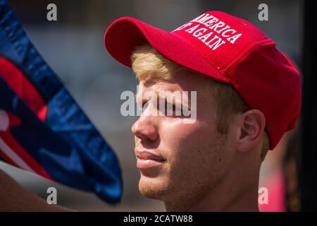 Bloomington, Usa. August 2020. Ein Protestler trägt eine Trump-Flagge und eine amerikanische Flagge, die während der Demonstration auf dem Morgan County Courthouse Square eine Trump-Mütze trägt.die BLM-Aktivisten wurden von bewaffneten Konterprotesten getroffen, die den Platz umzingelten. Kredit: SOPA Images Limited/Alamy Live Nachrichten Stockfoto