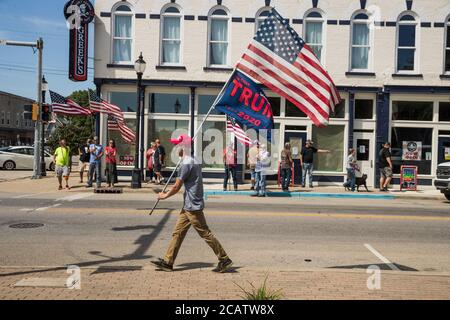 Bloomington, Usa. August 2020. Ein Protestler trägt eine Trump-Flagge und eine amerikanische Flagge während der Demonstration am Morgan County Courthouse Square.die BLM-Aktivisten wurden von bewaffneten Gegenprotesten getroffen, die den Platz umzingelten. Kredit: SOPA Images Limited/Alamy Live Nachrichten Stockfoto