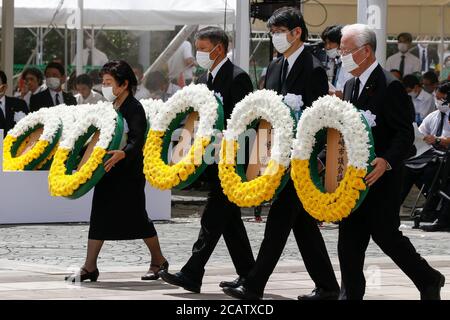 Nagasaki, Japan. August 2020. Teilnehmer mit Gesichtsmasken tragen Blumenkränze während der 75. Nagasaki Friedenszeremonie im Friedenspark. Um die Ausbreitung der neuen Coronavirus-Infektion zu verhindern, trugen die Teilnehmer Gesichtsmasken während der jährlichen Zeremonie, um für die Seelen derer zu beten, die während des Zweiten Weltkriegs bei den Atombomben in Nagasaki ums Leben kamen Quelle: Rodrigo Reyes Marin/ZUMA Wire/Alamy Live News Stockfoto