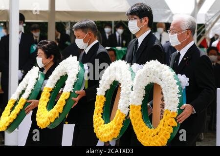 Nagasaki, Japan. August 2020. Teilnehmer mit Gesichtsmasken tragen Blumenkränze während der 75. Nagasaki Friedenszeremonie im Friedenspark. Um die Ausbreitung der neuen Coronavirus-Infektion zu verhindern, trugen die Teilnehmer Gesichtsmasken während der jährlichen Zeremonie, um für die Seelen derer zu beten, die während des Zweiten Weltkriegs bei den Atombomben in Nagasaki ums Leben kamen Quelle: Rodrigo Reyes Marin/ZUMA Wire/Alamy Live News Stockfoto