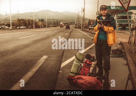 Wando/Südkorea-18.09.2016:der Anhalter bleibt auf der Straße und wartet auf Das Auto Stockfoto