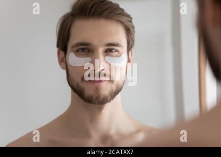 Kopf Schuss Spiegel Reflexion junger Mann mit Hydrogel Augenflecken Stockfoto