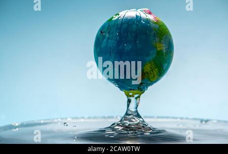Planet Erde in Form eines Globus in transparentem Wasser mit Spritzern. Konzept für umweltfreundliches Verhalten und sauberes Wasser Stockfoto