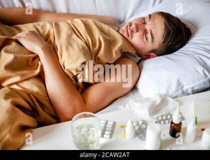 Kranker junger Mann im Bett zu Hause Stockfoto