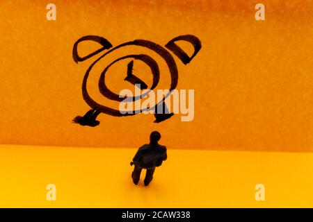 Miniatur Figur posierte als Geschäftsmann vor der handgezeichneten Uhr, Zeit-Management-Konzept Bild Stockfoto