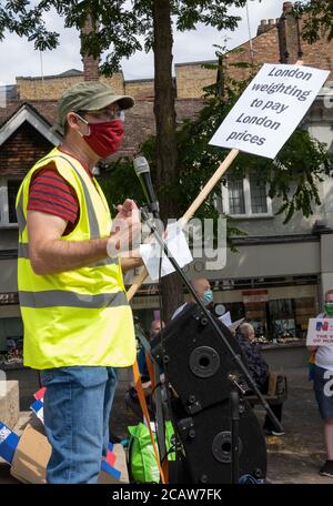 Oxford, Großbritannien. August 2020. NHS-Arbeiter und -Unterstützer nahmen an einer Kundgebung auf dem Bonner Platz in Oxford Teil, in der sie für Lohngerechtigkeit für alle NHS-Arbeiter aufriefen und protestierten, eine Lohnerhöhung zu fordern, um ihre Bemühungen während der covid Pandemie widerzuspiegeln.Dies war eine von etwa 38 ähnlichen Kundgebungen in ganz Großbritannien. Die Protestierenden behielten soziale Distanzierung aufrecht und trugen Masken. Während sie den Rednern zuhörten, hielten viele Plakate, die ihre Beschwerden und wie sie sich unterschätzt fühlten, hervorhoben. Im Bild spricht der Sprecher die Kundgebung. Quelle: Stephen Bell/Alamy Stockfoto