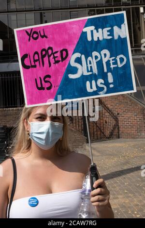 Oxford, Großbritannien. August 2020. NHS-Arbeiter und -Unterstützer nahmen an einer Kundgebung auf dem Bonner Platz in Oxford Teil, in der sie für Lohngerechtigkeit für alle NHS-Arbeiter aufriefen und protestierten, eine Lohnerhöhung zu fordern, um ihre Bemühungen während der covid Pandemie widerzuspiegeln.Dies war eine von etwa 38 ähnlichen Kundgebungen in ganz Großbritannien. Die Protestierenden behielten soziale Distanzierung aufrecht und trugen Masken. Während sie den Rednern zuhörten, hielten viele Plakate, die ihre Beschwerden und wie sie sich unterschätzt fühlten, hervorhoben. Abgebildet, Protestler mit Plakat - Sie haben uns dann geschlagen! Quelle: Stephen Bell/Alamy Stockfoto