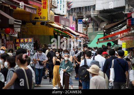 Menschen, die chirurgische Maske tragen und Shop unter dem Einfluss Von 'COVID-19' Stockfoto