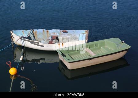 Zwei kleine Boote und eine Gelbe Festungsboje in der Sonne reflektiert auf dunkelblauem Wasser Stockfoto