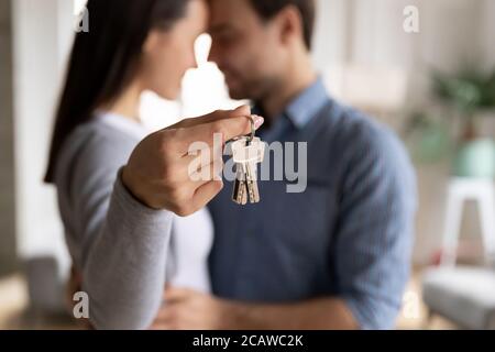 Emotionales glückliches Familienpaar, das Schlüssel aus dem neuen Haus vorführt. Stockfoto