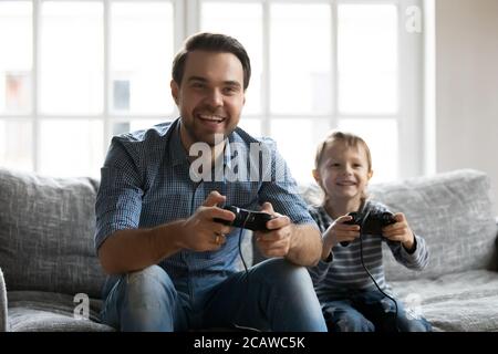 Überglücklich junger Vater spielt Videospiele mit kleinen Sohn. Stockfoto