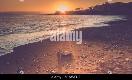 Touristen genießen den Strand und niemand legt sich in die Sonne - schöne farbige Sonnenuntergang im Hintergrund - Konzept der Reise Und Sommerurlaub Stockfoto