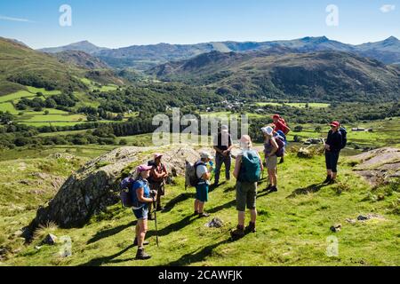 Wanderer ruhen auf Moel Hebog mit Blick auf die Berge im Snowdonia Nationalpark. Beddgelert, Gwynedd, Wales, Großbritannien Stockfoto