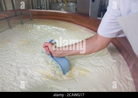 Person, die in der Gruyere Käserei in Frankreich arbeitet Stockfoto