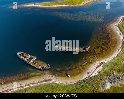 Luftaufnahme von verlassenen und verlassenen rostigen alten Schiffen in der Nähe von einsamen Insel im Arktischen Ozean. Russland. Weißes Meer Stockfoto