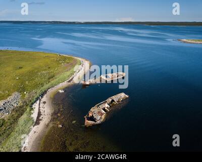 Luftaufnahme von verlassenen und verlassenen rostigen alten Schiffen in der Nähe von einsamen Insel im Arktischen Ozean. Russland. Weißes Meer Stockfoto