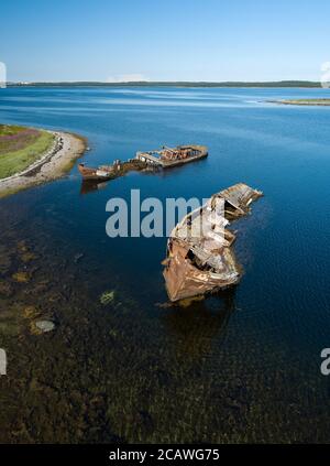 Luftaufnahme von verlassenen und verlassenen rostigen alten Schiffen in der Nähe von einsamen Insel im Arktischen Ozean. Russland. Weißes Meer Stockfoto