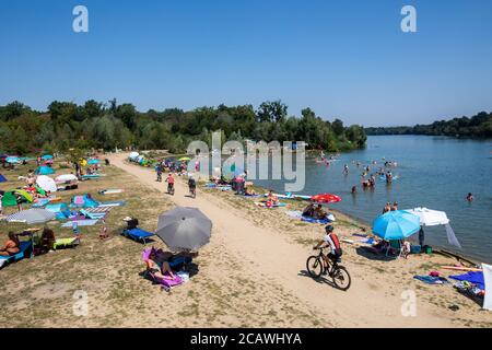 Freiburg, Deutschland. August 2020. Badegäste stehen und liegen in der Sonne oder baden im Grünen des Opfinger See. Die sommerlichen Temperaturen ziehen viele Menschen an die Badeseen, aber weniger als befürchtet. Laut DLRG ist die Zahl der bundesweiten Badetodesfälle im Vergleich zum Vorjahr zurückgegangen. Quelle: Philipp von Ditfurth/dpa/Alamy Live News Stockfoto