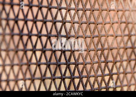Rostiger Zaun aus Metallgeflecht, rhombische Zellen. Weichfokus. Seitenansicht Stockfoto