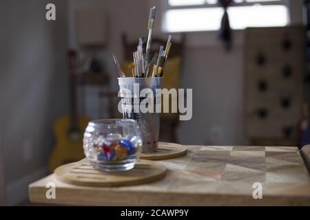 Nahaufnahme von einem Glas Murmeln und Tasse Bürsten innen lackieren Stockfoto