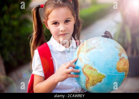 Zurück zur Schule. Schüler Mädchen halten Globus im Freien. Geografie- und Bildungskonzept Stockfoto