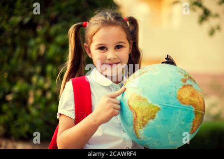 Zurück zur Schule. Schüler Mädchen halten Globus im Freien. Geografie- und Bildungskonzept Stockfoto