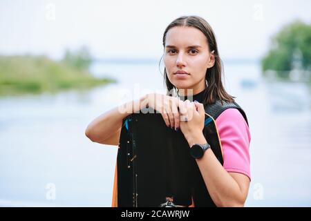 Aktive junge Surferin in Sportswear Surfen am Wasser Sportresort Stockfoto