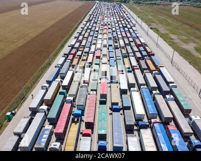 LKWs, die am Hafen anstehen, um Getreide zu entladen. Transport- und Logistikkonzept. Stockfoto