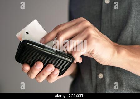 Mann mit kontaktloser Kreditkarte in einer Brieftasche mit RFID-Schutz. Stockfoto