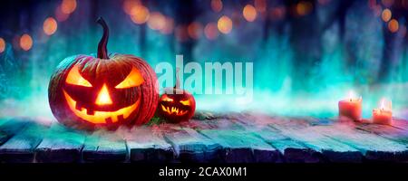 Jack O’ Laternen in Spooky Forest mit Nebel und Kerzen - Halloween Hintergrund Mit Farben Trend Stockfoto