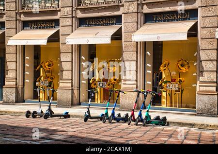 Mailand, Italien 08.08.2020: Elektroroller Parken vor den Displays eines Trussardi-Stores in der Innenstadt Mailands Stockfoto