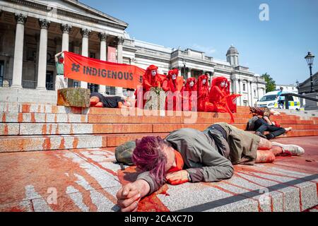 09/08/20 London, Vereinigtes Königreich. XR-Aktivisten haben die Treppen des Trafalgar Square abgedeckt. Mit gefälschtem Blut zum Internationalen Tag der indigenen Völker der Welt Stockfoto
