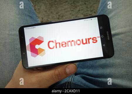 Mann mit Smartphone und Chemours Company Logo Stockfoto