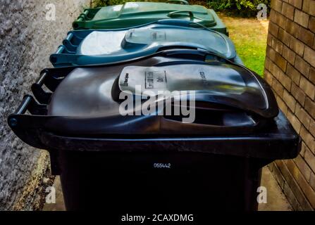Linie von drei Mülltonnen, die von einem gemeinderat für britische Hausbewohner für Haushaltsabfälle bereitgestellt werden, getrennt durch recycelbare, nicht recycelbare und Garten. Stockfoto