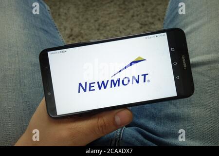 Mann hält Smartphone mit Newmont Mining Corporation Logo Stockfoto