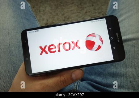 Mann hält Smartphone mit Xerox Corporation Logo Stockfoto