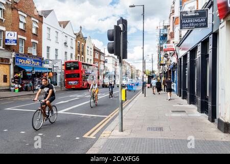 Radfahrer auf Green Lanes in Harringay, einem normalerweise blühenden und belebten Einkaufsviertel, während der Coronavirus-Pandemie, North London, Großbritannien Stockfoto