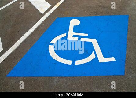 Ein Parkplatz für behinderte Fahrer mit internationalem Symbol für den Zugang (ISA), der eine Person im Rollstuhl zeigt. Stockfoto