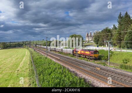 DB Cargo-Lokomotive der Baureihe 66, die einen Güterzug mit Kalkablagerungen von Tata Hardendale auf der Westküsten-Hauptstrecke bei Shapfell abtransportiert Stockfoto
