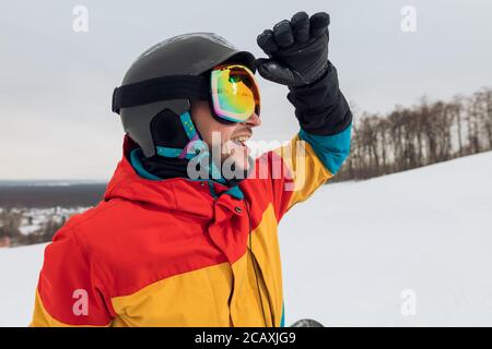 Glückliche junge Sportler Sonnenbrillen. Nahaufnahme Seitenansicht Foto, Freizeit, Freizeit, Kerl ist die Erkundung der Gegend für Snowboading Stockfoto