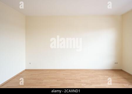 Leeres Zimmer in einer Wohnung mit hellen Wänden und Holzdekor Laminat auf dem Boden, Konzept für Wohnungsmangel, Immobilien-Investitionen und Miete incre Stockfoto